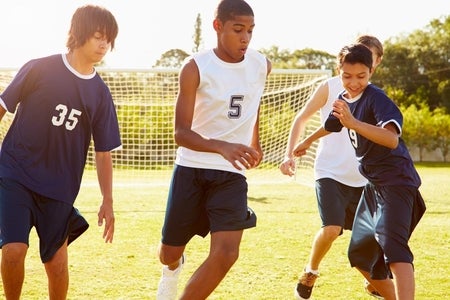 Teenagers playing soccer